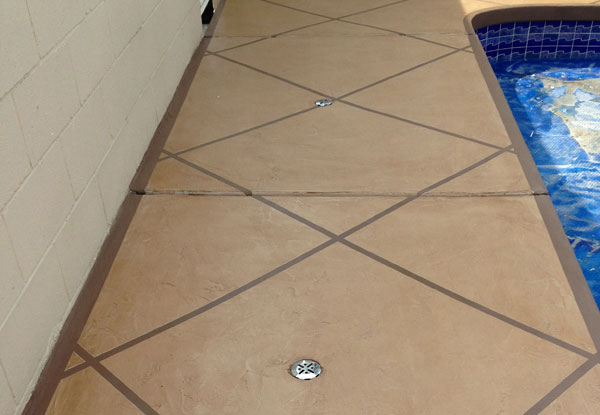 Pool deck resurfaced with a scored coating finish