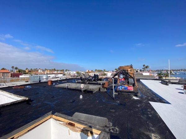 Crank crew working on a flat roof replacement